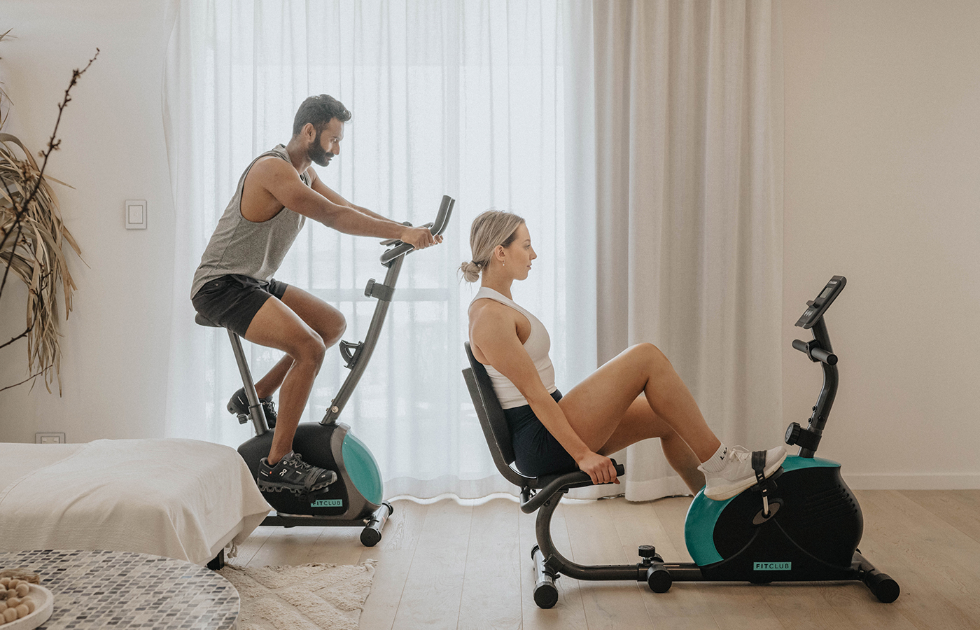 Two young people performing spin bike interval training routines