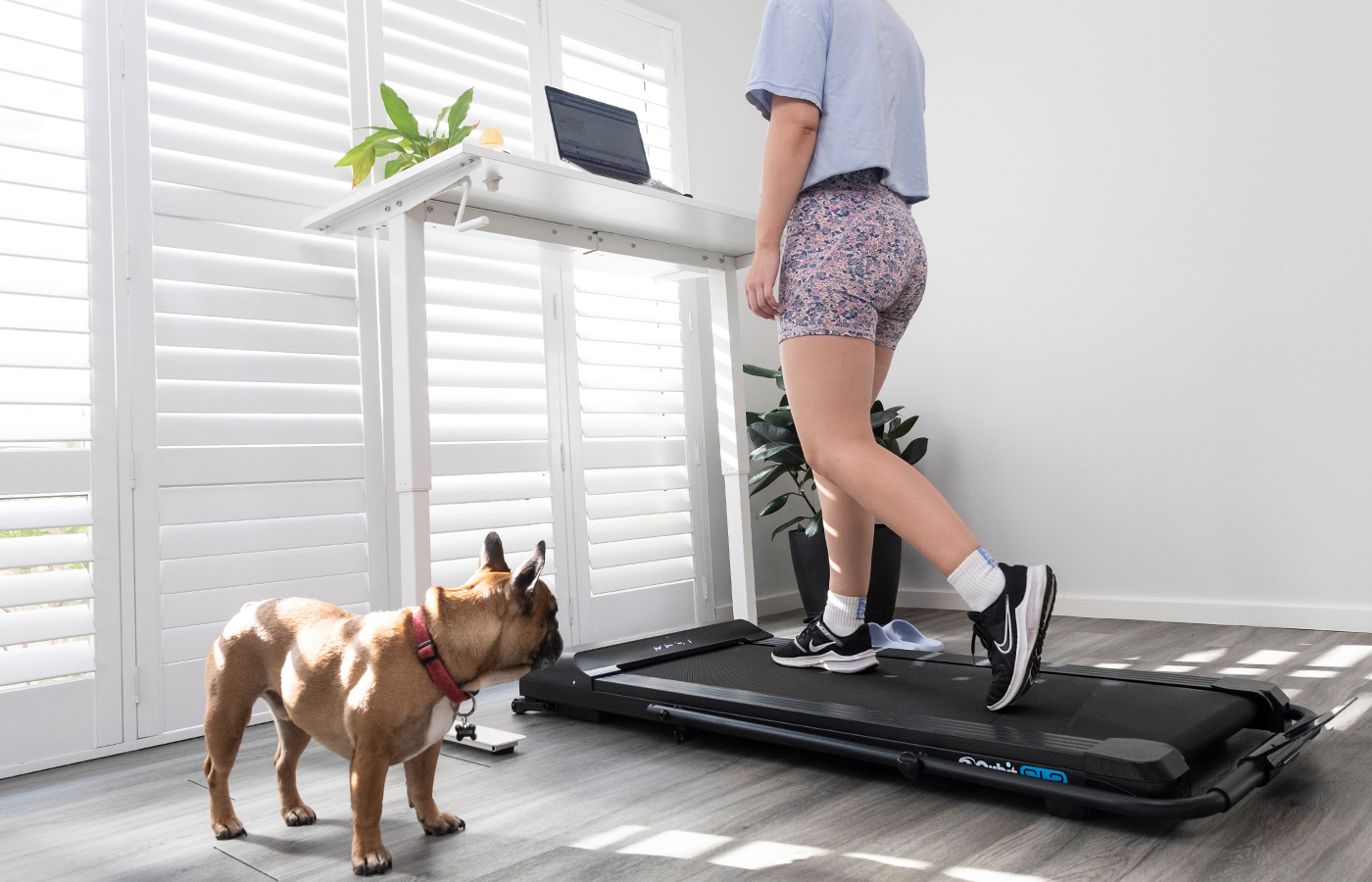 A woman gaining the benefits of her under desk treadmill while working from home